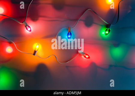 Ein Strang der bunten großen Weihnachtsbaum Lichter leuchten auf weißem Hintergrund Studioportrait gedimmt Stockfoto