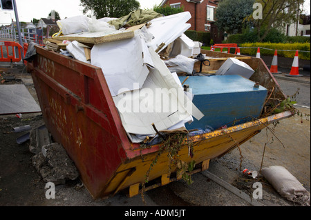 Bauherren überspringen voller Hausmüll und Abfälle durch Hauptverbesserungen am Straßenrand sitzen Herzinfarkt Stockfoto