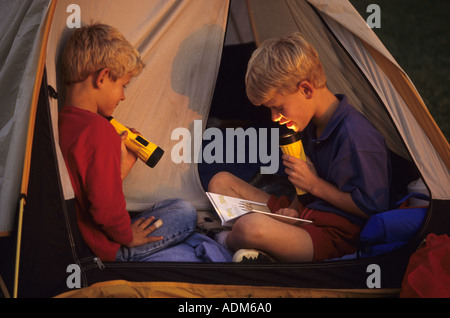 Zwei jungen im Lesen von Taschenlampen-Zelt Stockfoto