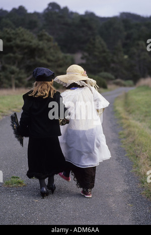Ansicht von hinten von zwei kleinen Mädchen Fuß Straße in dress-up-Kleidung Stockfoto
