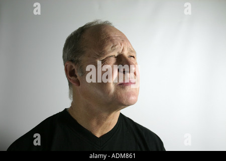 Mann in seinen Sechzigern schielt auf etwas in der Ferne Stockfoto