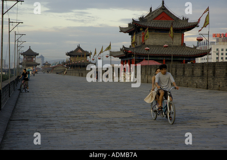 Paar mit dem Fahrrad entlang der Stadtmauer von der Stadtmauer von Xian, Xian, Shaanxi, China - in der Abenddämmerung. Stockfoto