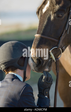 Ein bewegender Moment während der Waffenruhe zwischen Teen Mädchen und ihr Pferd beim Springreiten event Stockfoto