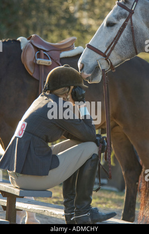 Ein bewegender Moment während der Waffenruhe zwischen Teen Mädchen und ihr Pferd beim Springreiten event Stockfoto