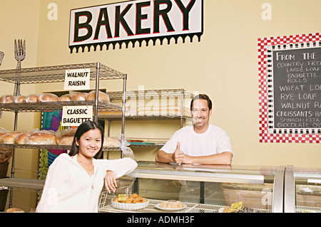 Mann und Frau in der Bäckerei lächelnd und Blick in die Kamera, Porträt. Stockfoto