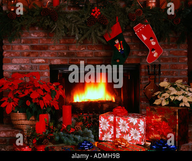 Weihnachten Kamin Stillleben lodernden gemauerten Kamin mit Strümpfen Weihnachtsstern und Urlaub Artikel anzeigen Stockfoto