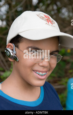 Junge mit Brille und Bluetooth-Kopfhörer sieht in die Kamera. Stockfoto