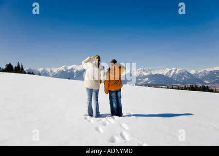 Frau mit jungen Mann in einer tief verschneiten Winterlandschaft Stockfoto