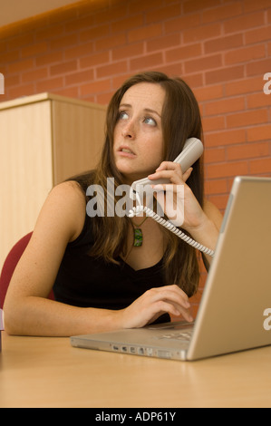 Frau am Telefon bei der Verwendung von Apple Powerbook Computer im modernen Büro Stockfoto