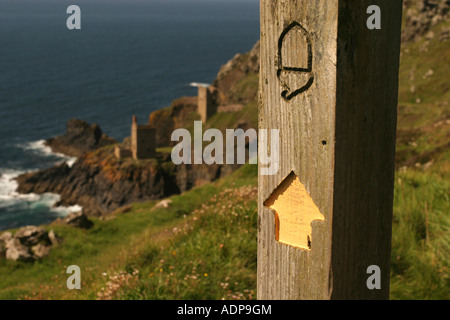 Wanderweg Richtung Schild mit Krone Maschinenhäuser auf Botallack Cornwall im Hintergrund Stockfoto