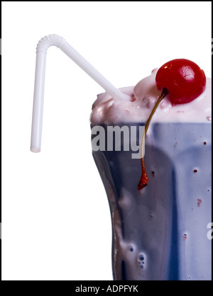 Nahaufnahme des Schmelzens Milchshake mit Stroh und Maraschino-Kirsche Stockfoto