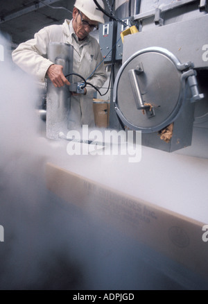 Ein Arbeitnehmer nutzt eine Maschine Einfrieren Lebensmittel in einer Fabrik zu blinken Stockfoto