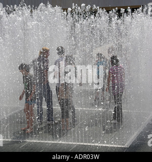 Londoner Southbank komplexen erscheinenden Räumen boxed Brunnen Wasserspiel im stehen und versuchen, trocken zu bleiben oder um sich abzukühlen Stockfoto