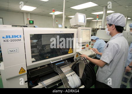 Chinesischen High Tech Fabrikarbeiter an Maschine für die Umsetzung von Komponenten auf LSD Display-Module Stockfoto