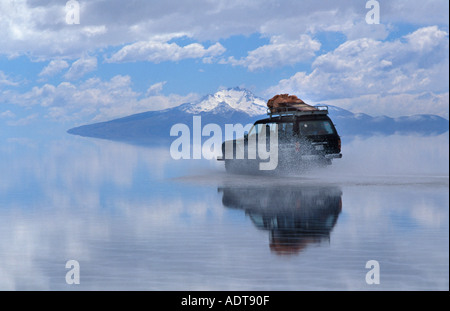 Reisende, die über dem Salzsee Salar de Uyuni in einem 4 x 4 Schneeschmelze verlassen reflektierende Oberfläche Bolivien S Amerika Stockfoto