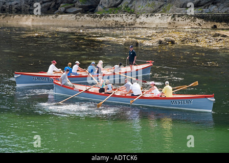 Charlestown Ufer gemischte Crew Ruder zwei von einer Art langen Piloten Gig Row Boote bereiten sich auf das Rasen auf das Meer und zurück in der Nähe von St Austell Cornwall England vor Stockfoto