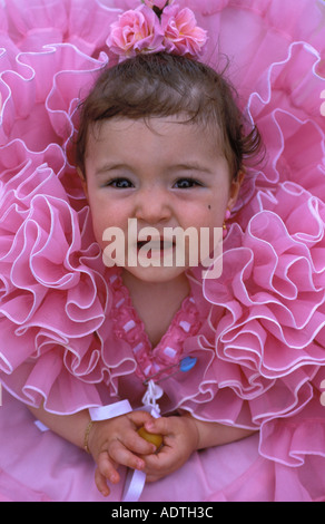 Sevilla ein kleines Mädchen in einem rosa Flamenco-Kleid bei der Feria de abril Stockfoto