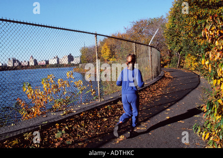 Jacqueline Kennedy Onassis Reservoir im Herbst in New York City. Junge Frau beim Joggen. Auch bekannt als Central Park Reservoir.Central Park Conservancy Stockfoto