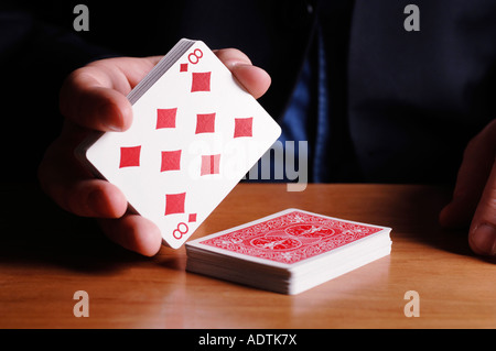 Mann-Mähwerk Karten auf acht Diamanten Stockfoto