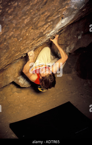 Frau Bouldern auf einem steilen überhängenden Felsblock Problem. Stockfoto