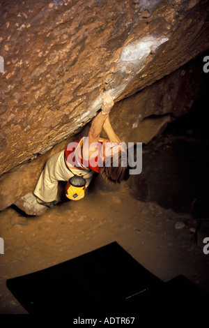 Frau Bouldern auf einem steilen überhängenden Felsblock Problem. Stockfoto