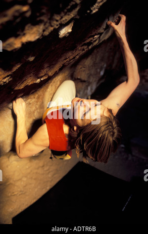 Frau Bouldern auf einem steilen überhängenden Felsblock Problem. Stockfoto