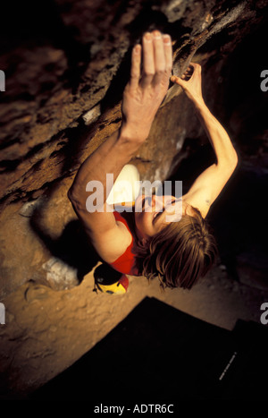 Frau Bouldern auf einem steilen überhängenden Felsblock Problem. Stockfoto