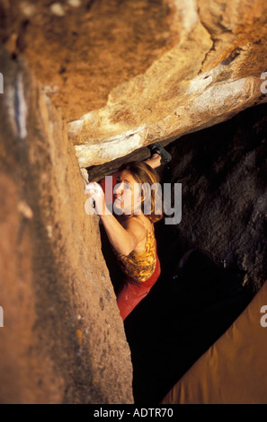 Frau Bouldern auf einem steilen überhängenden Felsblock Problem. Stockfoto