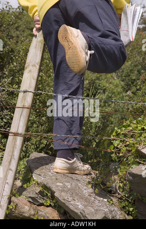 Person Überklettern ländlichen öffentlichen Weg Fußweg Stil durch Stacheldraht versperrt Stockfoto