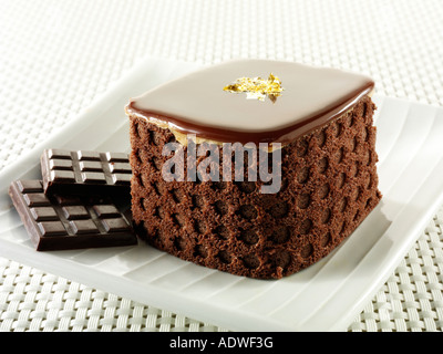 Eine handgemachte Patisserie Spezialität reichen verwöhnenden Schokoladenkuchen mit Kaffee in einem weißen Tisch Einstellung gefüllt Stockfoto