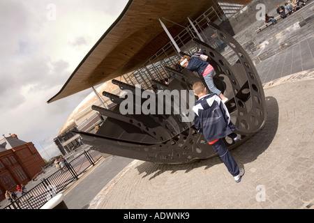 Wales Cardiff Bay Senedd Nationalversammlung Kinder spielen am Kriegerdenkmal Händler Seeleute Stockfoto