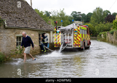 Feuerwehr Pumpe Wasser aus überfluteten Haus in Naunton Cotswolds Gloucestershire England Großbritannien Stockfoto