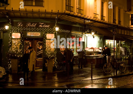 Menschen Schutz vor Regen in der Nacht auf der Straße Ecke außerhalb traditioneller Le Petit Zinc Restaurant Rive Gauche Paris Frankreich Stockfoto