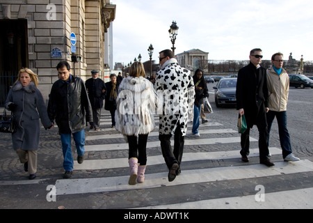 Fußgänger im Wintermäntel zu Fuß über gepflasterte Straße am Zebrastreifen in Place De La Concorde Central Paris Frankreich Stockfoto