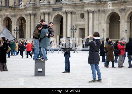 Junge Touristen Spaß versuchen, balance auf posiert Sockel vor dem Louvre Museum Central Paris Frankreich Stockfoto