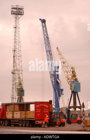 GABEL LIFT TRUCKS AUFZÜGE HOLZ AUF EINES SATTELSCHLEPPERS AUF DAS DOCKSIDE EINEN HAFEN IN NEWPORT SOUTH WALES UK Stockfoto