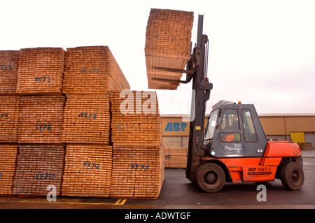 EINE GABELSTAPLER HEBT HOLZ AUF DAS DOCKSIDE EINEN HAFEN IN NEWPORT SOUTH WALES UK Stockfoto