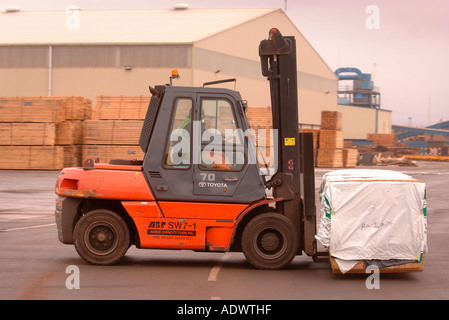 EINE GABELSTAPLER HEBT HOLZ AUF DAS DOCKSIDE EINEN HAFEN IN NEWPORT SOUTH WALES UK Stockfoto