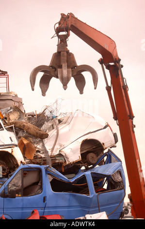 EIN MECHANISCHER LADER MIT EINEM GRAPPLING-ARM BEI EINER METALL-RECYCLING ANLAGE AUF DAS DOCKSIDE EINEN HAFEN IN NEWPORT SOUTH WALES UK Stockfoto