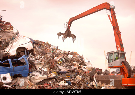 EIN MECHANISCHER LADER MIT EINEM GRAPPLING-ARM BEI EINER METALL-RECYCLING ANLAGE AUF DAS DOCKSIDE EINEN HAFEN IN NEWPORT SOUTH WALES UK Stockfoto