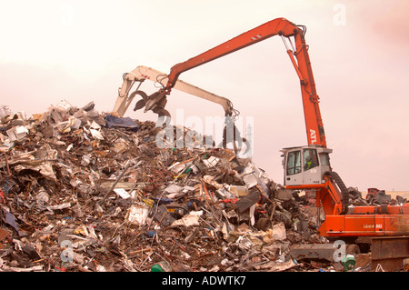 EIN MECHANISCHER LADER MIT EINEM GRAPPLING-ARM BEI EINER METALL-RECYCLING ANLAGE AUF DAS DOCKSIDE EINEN HAFEN IN NEWPORT SOUTH WALES UK Stockfoto