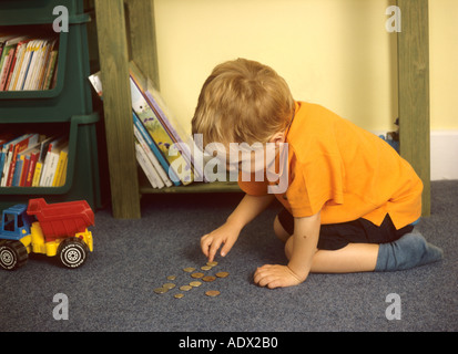 Kleiner Junge Münzen auszählen Stockfoto