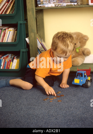 Kleiner Junge Münzen auszählen Stockfoto