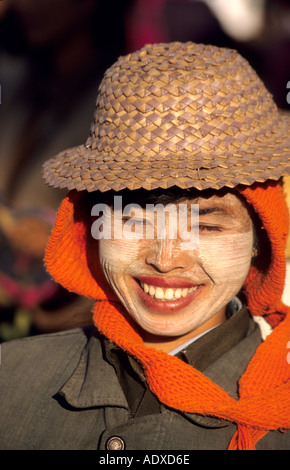 Lächelnd burmesischen Mädchen trägt einen Strohhut mit Tanaka gemalt auf ihren Wangen als Sonnenschutz und Dekoration. Stockfoto