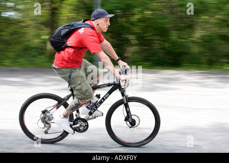 Junge Radfahrer mit tätowierten Beine auf Mountainbike fährt bergab eine Landschaft Straße Ramberget Park Göteborg Schweden Stockfoto