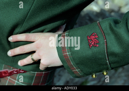 Mann trägt Welsh kilt in St Davids Tartan Detail des roten Drachen auf Jacke Ärmel an Wales UK Stockfoto