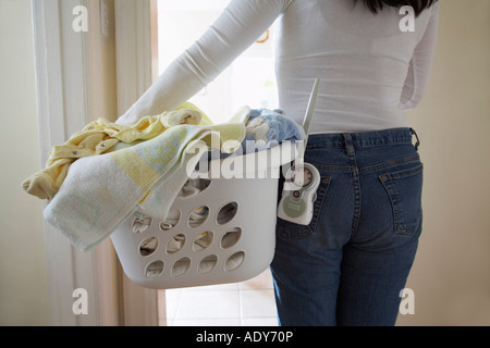 Frau mit Wäschekorb und Babyphone Stockfoto