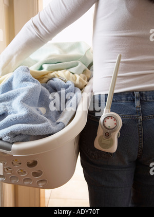 Frau mit Wäschekorb und Babyphone Stockfoto