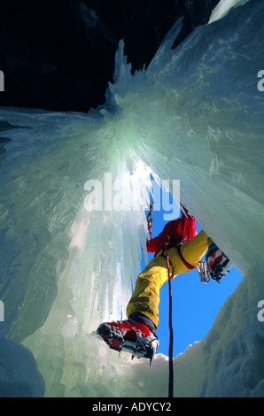 Eiskletterer, Blick durch Loch im gefrorenen Wasserfall Stockfoto