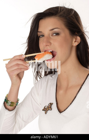 Brünette Frau Sushi mit Stäbchen zu essen. Stockfoto